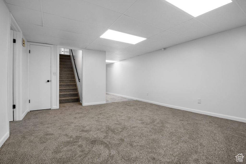Basement featuring a paneled ceiling and carpet