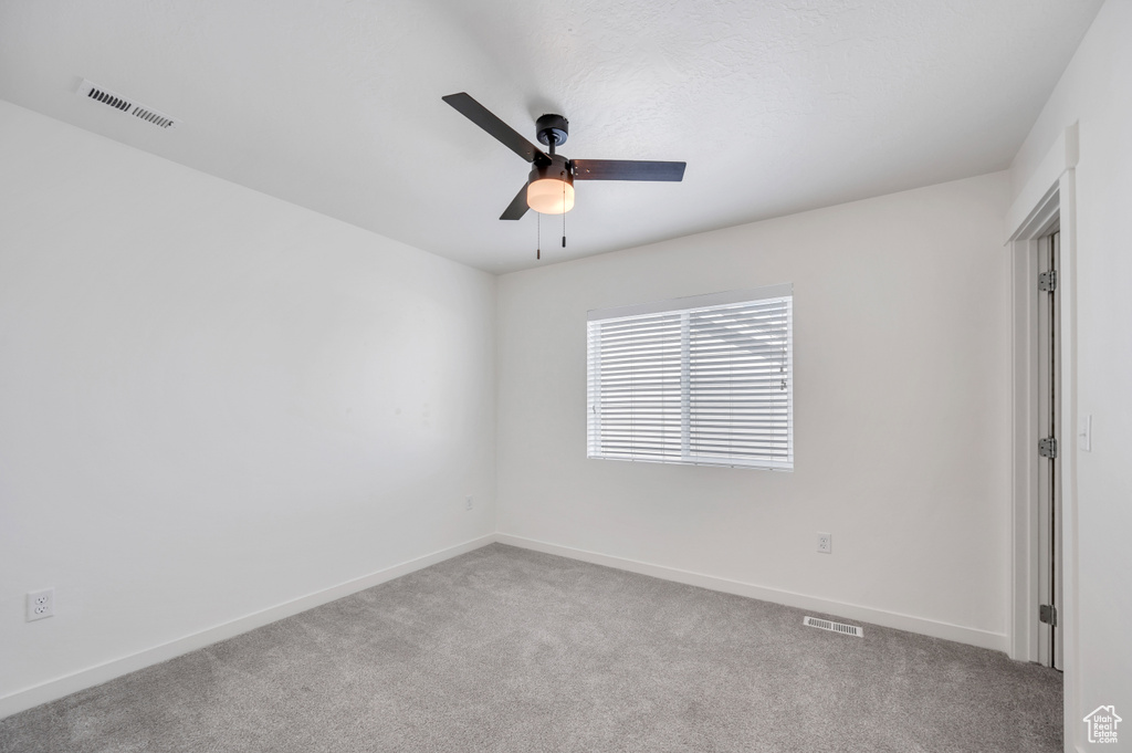 Unfurnished room featuring ceiling fan and carpet floors