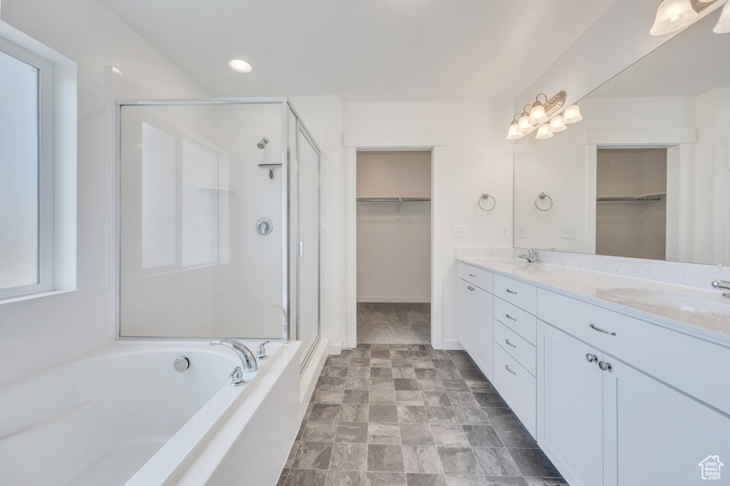 Bathroom with large vanity, independent shower and bath, double sink, and tile flooring