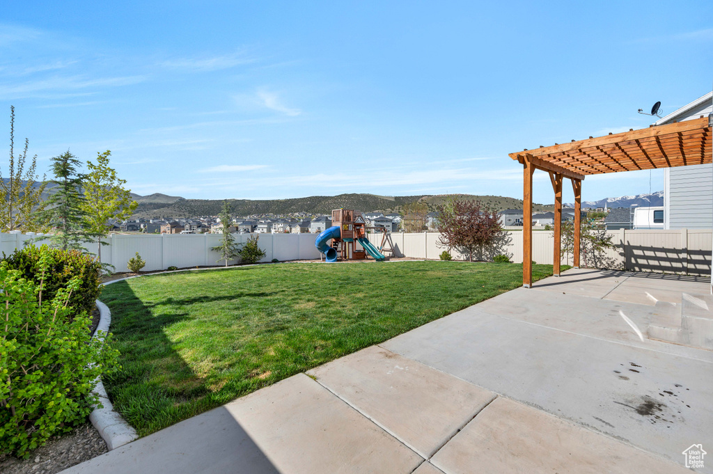 View of yard featuring a patio area, a mountain view, a playground, and a pergola