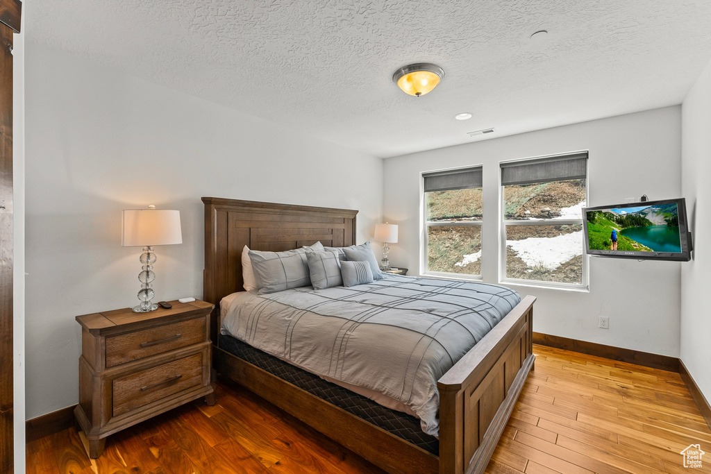 Bedroom featuring light hardwood / wood-style flooring and a textured ceiling