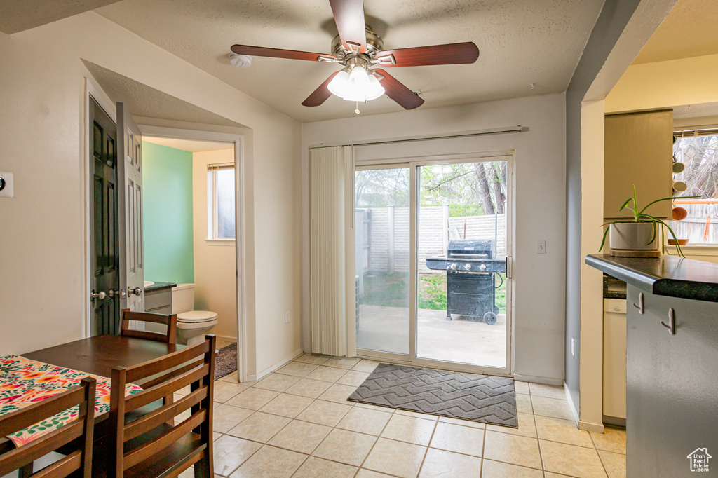 Doorway featuring ceiling fan and light tile floors