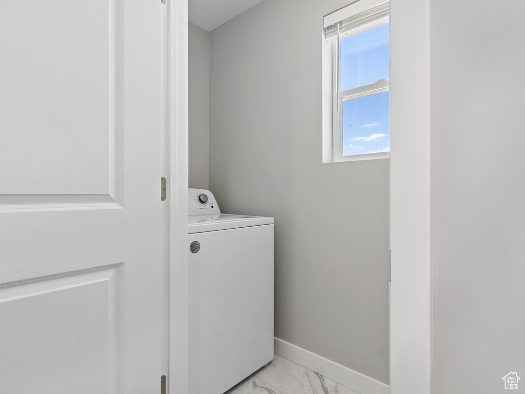 Washroom with washer / dryer and light tile flooring