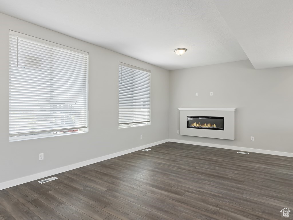 Unfurnished living room with dark hardwood / wood-style floors