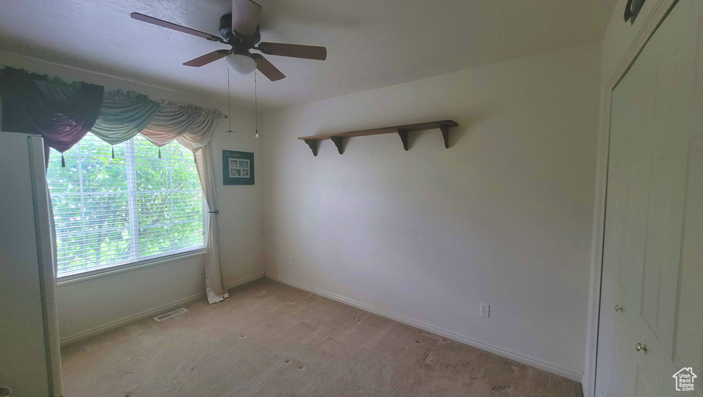 Empty room with ceiling fan and carpet floors