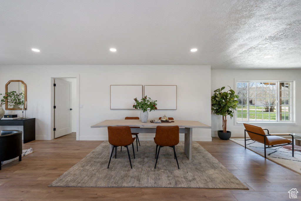 Dining space featuring hardwood / wood-style flooring and a textured ceiling