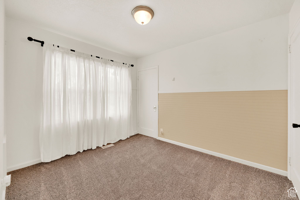 Empty room with carpet floors and lofted ceiling