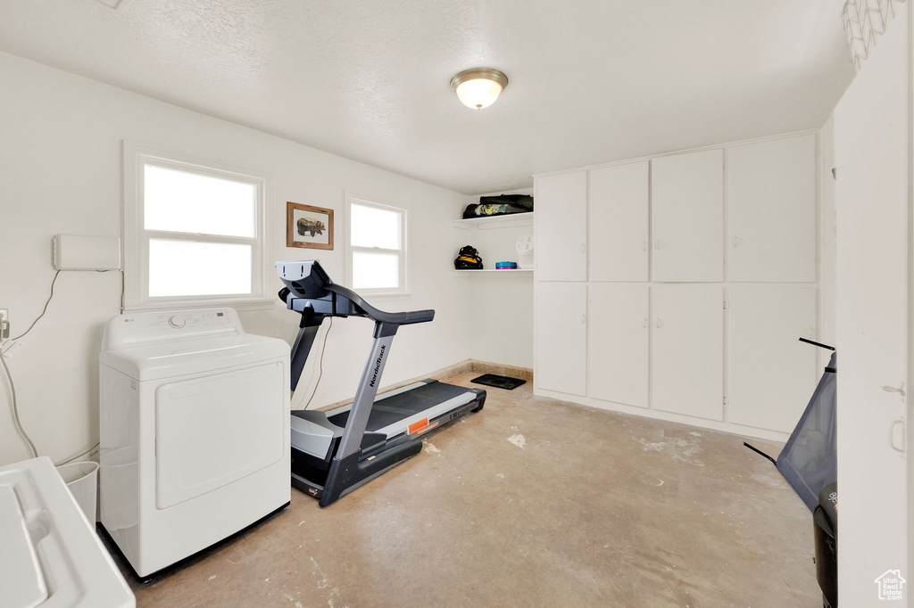 Exercise room featuring washer / dryer and a textured ceiling