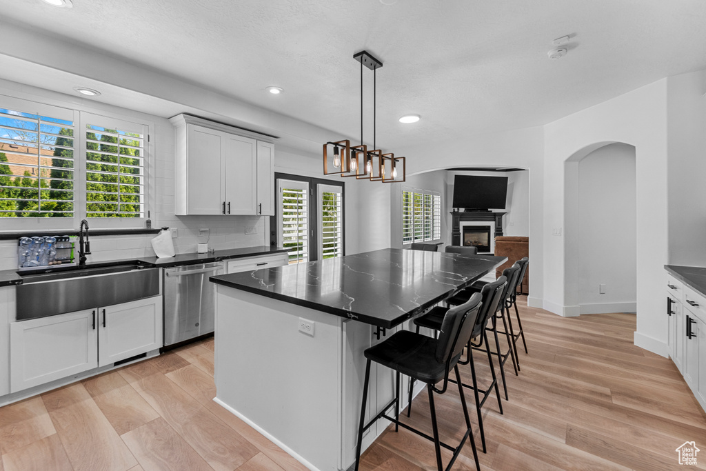 Kitchen featuring light hardwood / wood-style flooring, sink, a center island, and stainless steel dishwasher