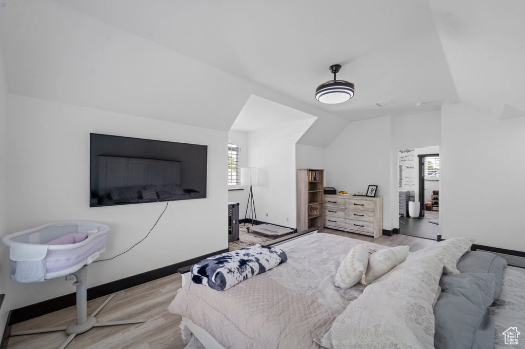 Bedroom featuring lofted ceiling and light wood-type flooring