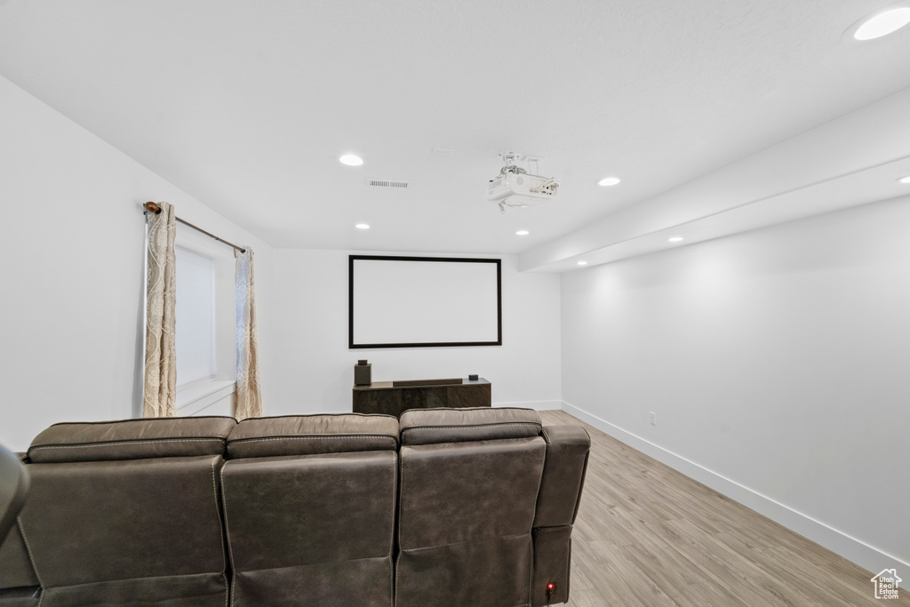 Home theater room with light hardwood / wood-style flooring