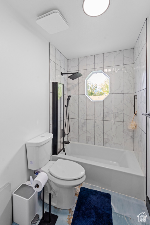 Bathroom with toilet, tile floors, and tiled shower / bath combo