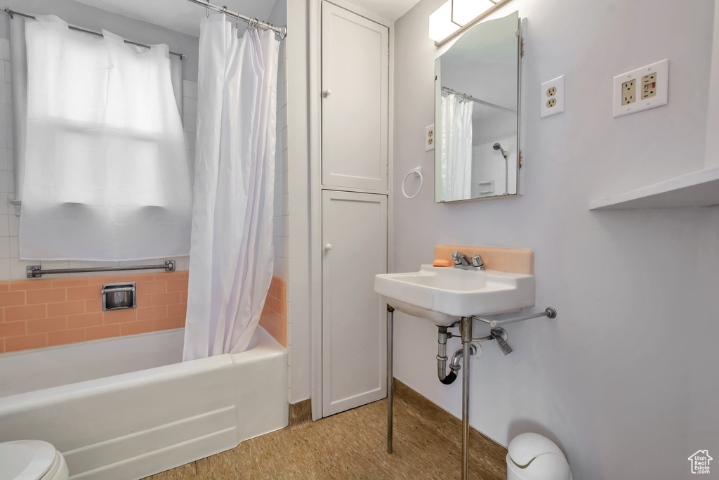 Bathroom with shower / bath combination with curtain and toilet
