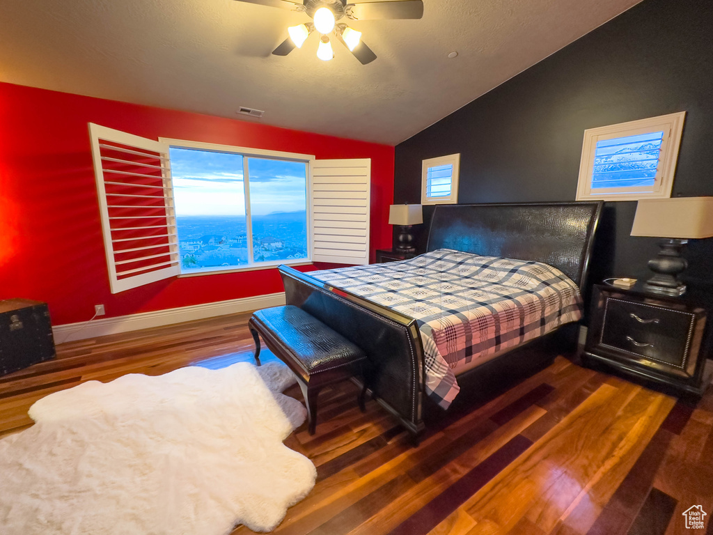 Bedroom with ceiling fan, dark hardwood / wood-style flooring, and lofted ceiling