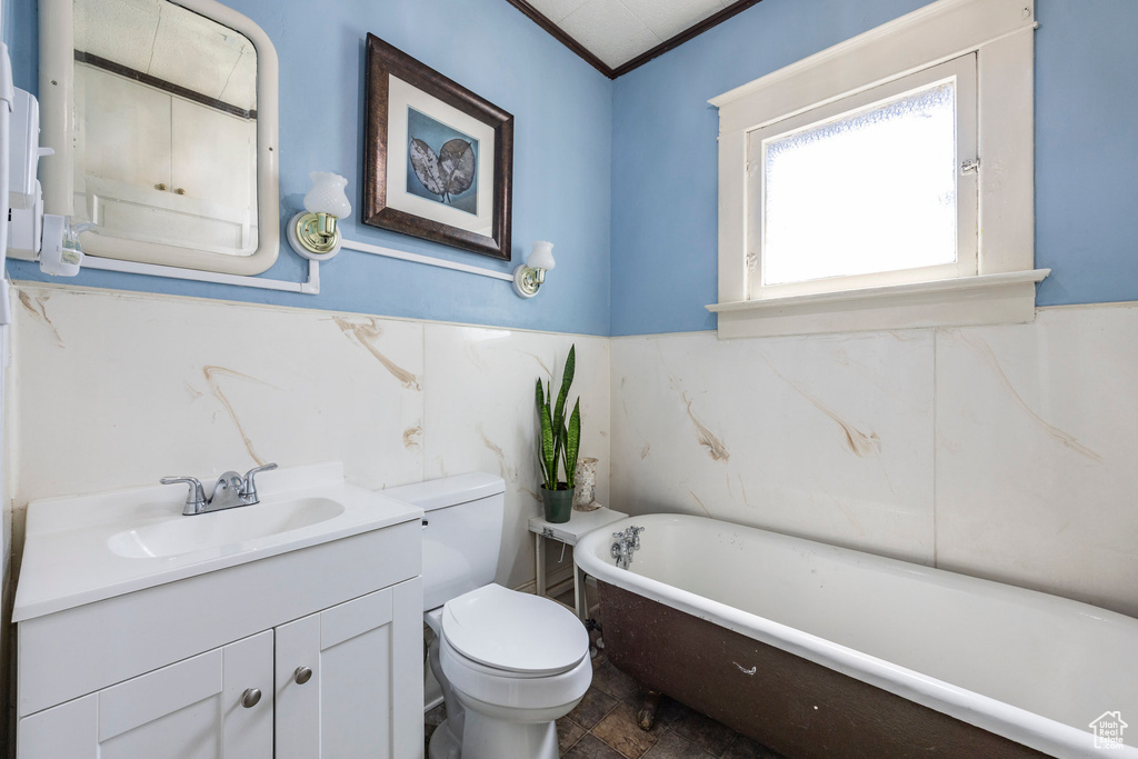 Bathroom with crown molding, large vanity, tile flooring, a bathing tub, and toilet