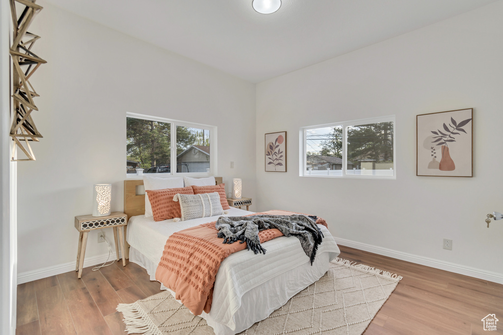 Bedroom featuring multiple windows and hardwood / wood-style flooring