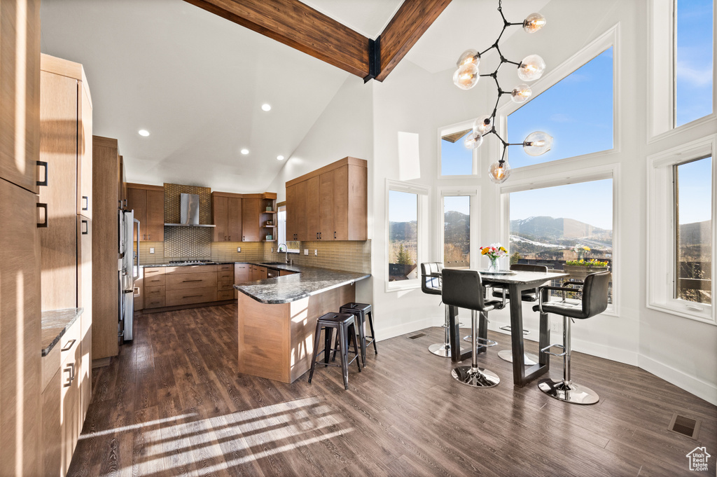 Kitchen with backsplash, dark wood-type flooring, a mountain view, and a breakfast bar