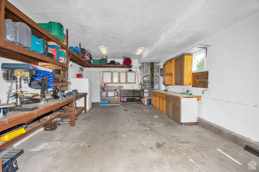 Garage with white fridge and a workshop area