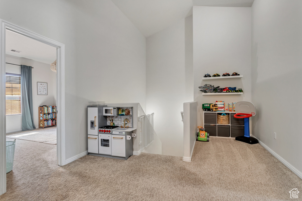Rec room with light colored carpet and lofted ceiling