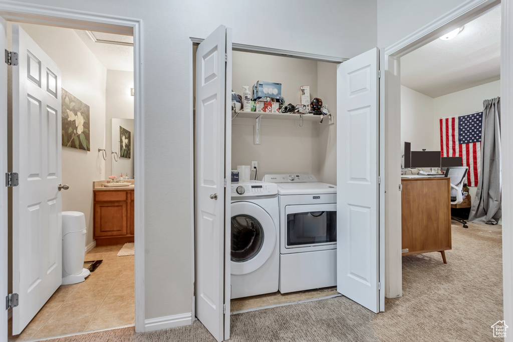 Clothes washing area with light colored carpet and washing machine and dryer