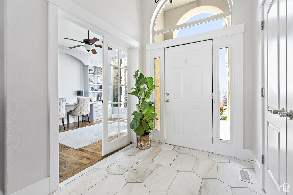 Entryway with light tile floors, plenty of natural light, and ceiling fan