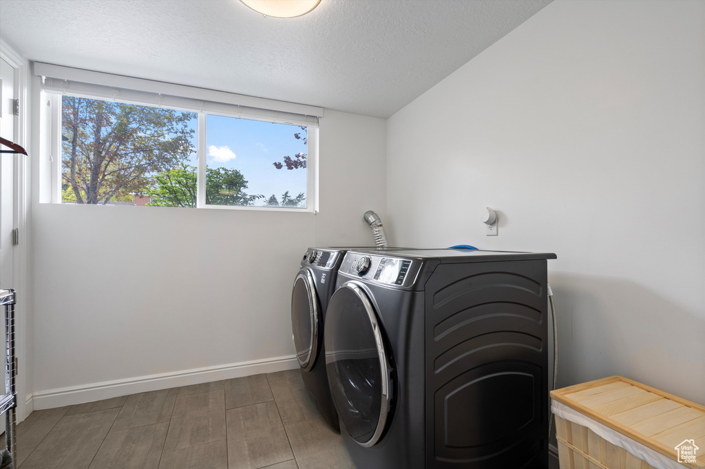 Laundry room with independent washer and dryer and hardwood / wood-style floors