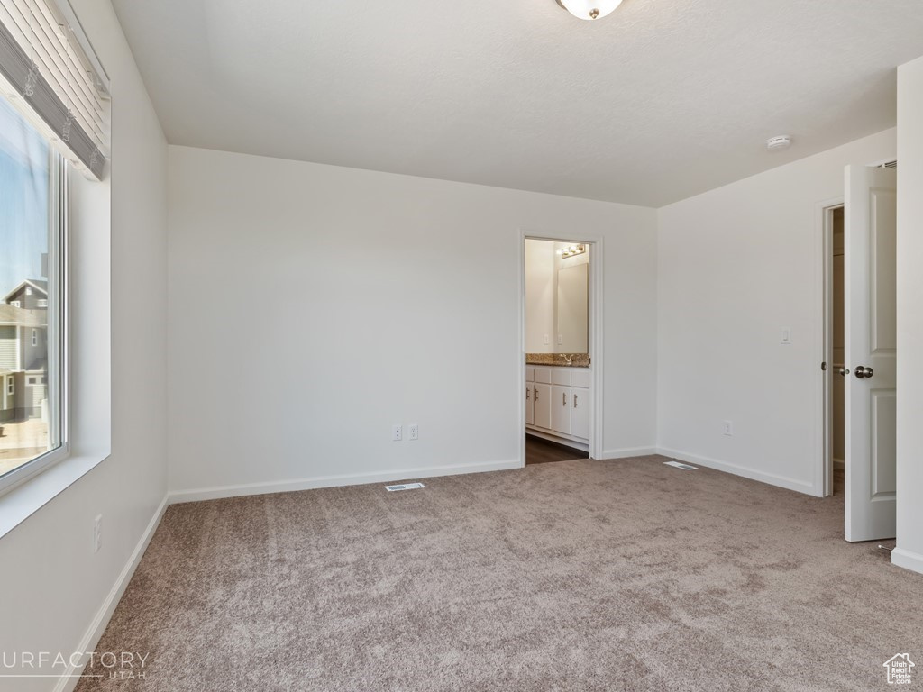 Unfurnished bedroom with carpet and connected bathroom