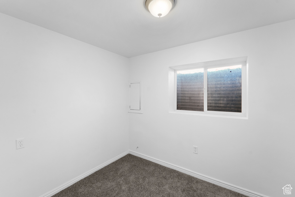 Spare room with dark colored carpet