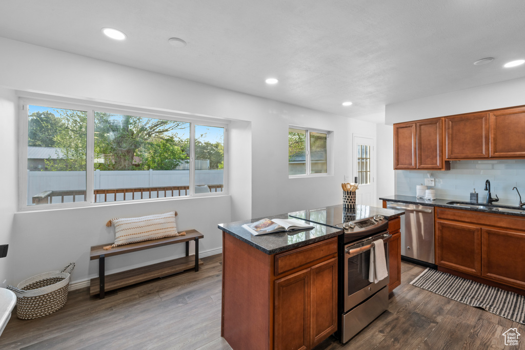 Kitchen featuring hardwood / wood-style floors, sink, appliances with stainless steel finishes, and a kitchen island