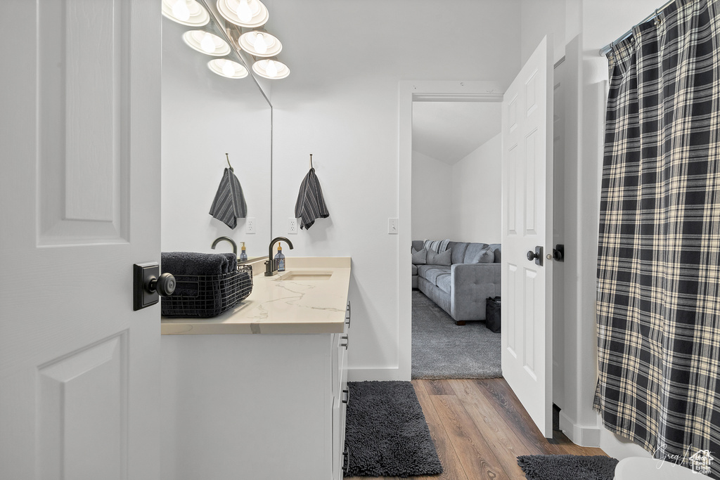 Bathroom featuring hardwood / wood-style floors, vanity, and a notable chandelier