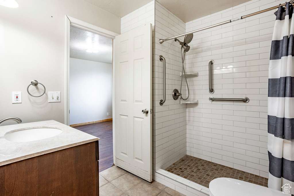 Bathroom with wood-type flooring, vanity, toilet, and a shower with shower curtain