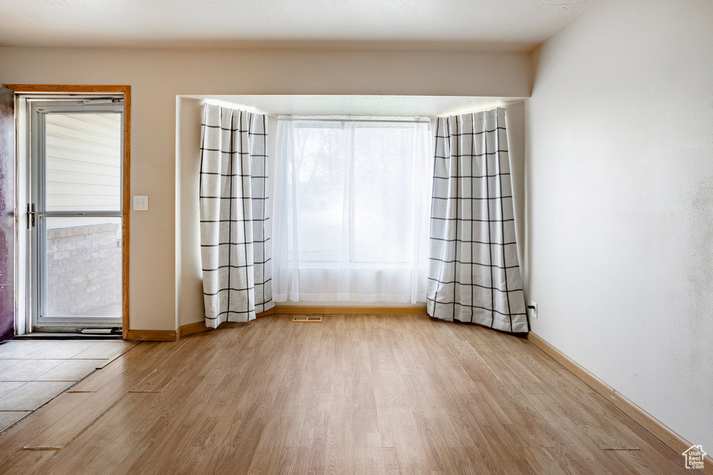 Spare room featuring light hardwood / wood-style flooring and plenty of natural light