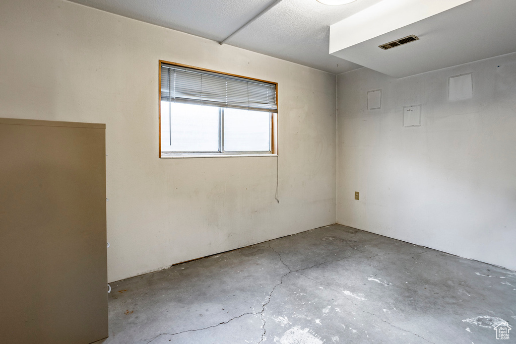 Spare room with concrete floors and a textured ceiling