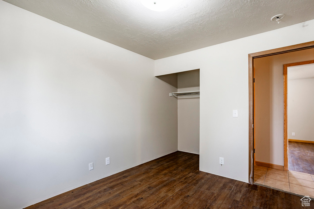 Unfurnished bedroom with tile floors, a closet, and a textured ceiling