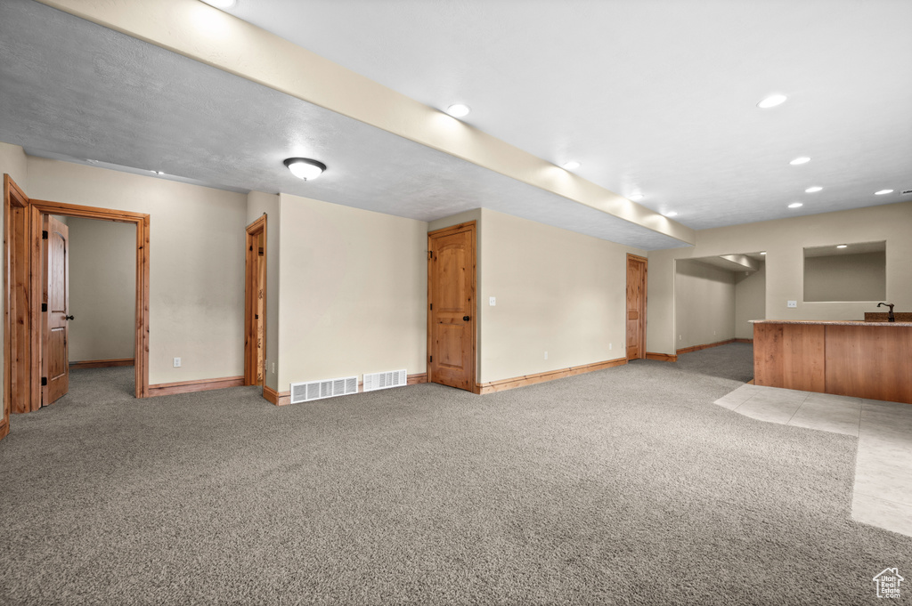 Basement featuring carpet and sink