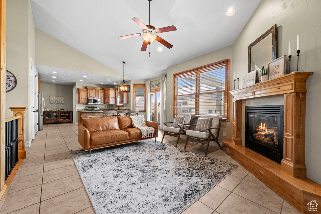 Living room with high vaulted ceiling, ceiling fan, and light tile flooring