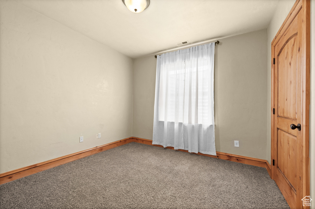 Unfurnished room featuring carpet floors and vaulted ceiling