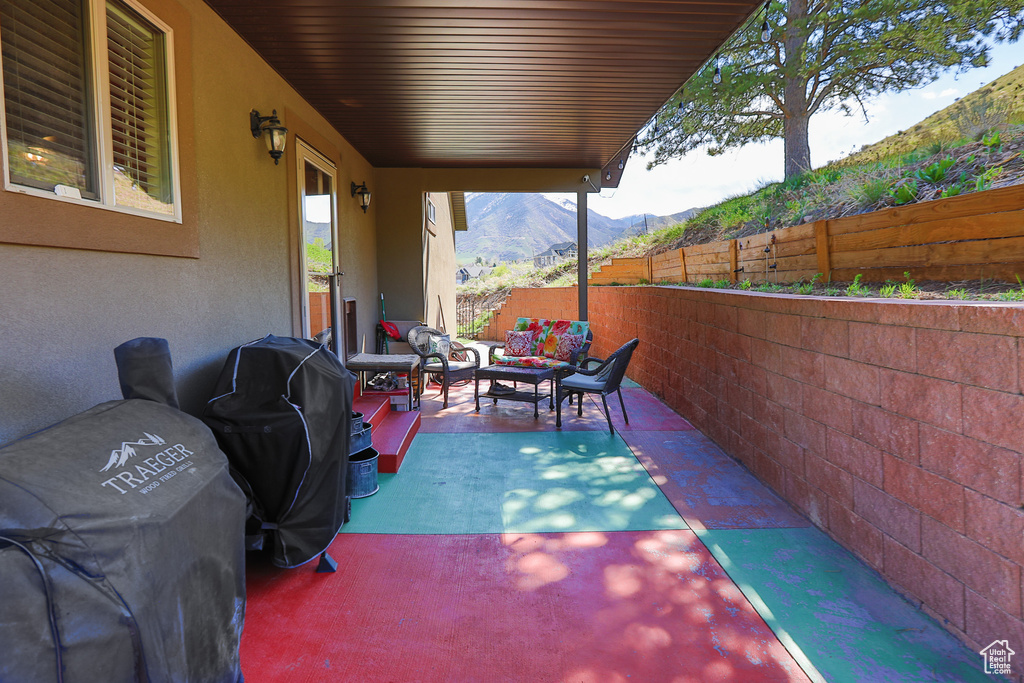 View of terrace featuring an outdoor living space, a mountain view, and area for grilling