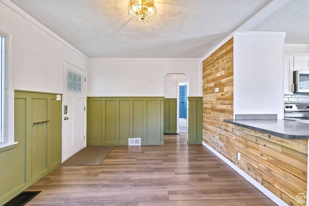 Foyer with wood walls, plenty of natural light, and hardwood / wood-style floors