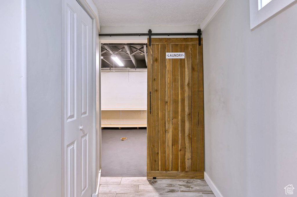 Hallway with a barn door and light carpet