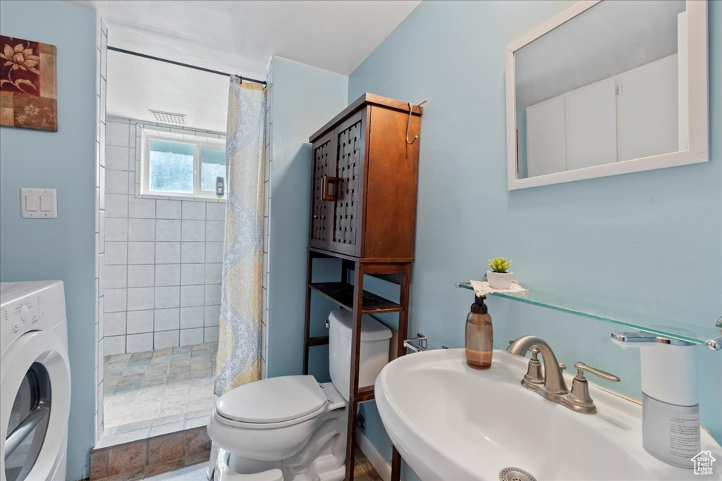 Bathroom with sink, washer / dryer, and toilet
