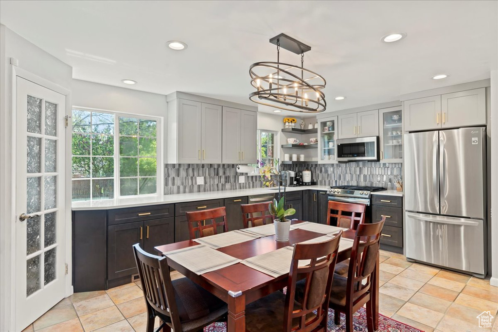 Kitchen with plenty of natural light, stainless steel appliances, tasteful backsplash, and light tile flooring