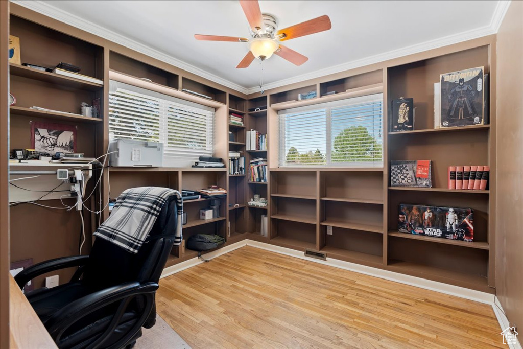 Office space with a healthy amount of sunlight, light hardwood / wood-style flooring, ceiling fan, and ornamental molding