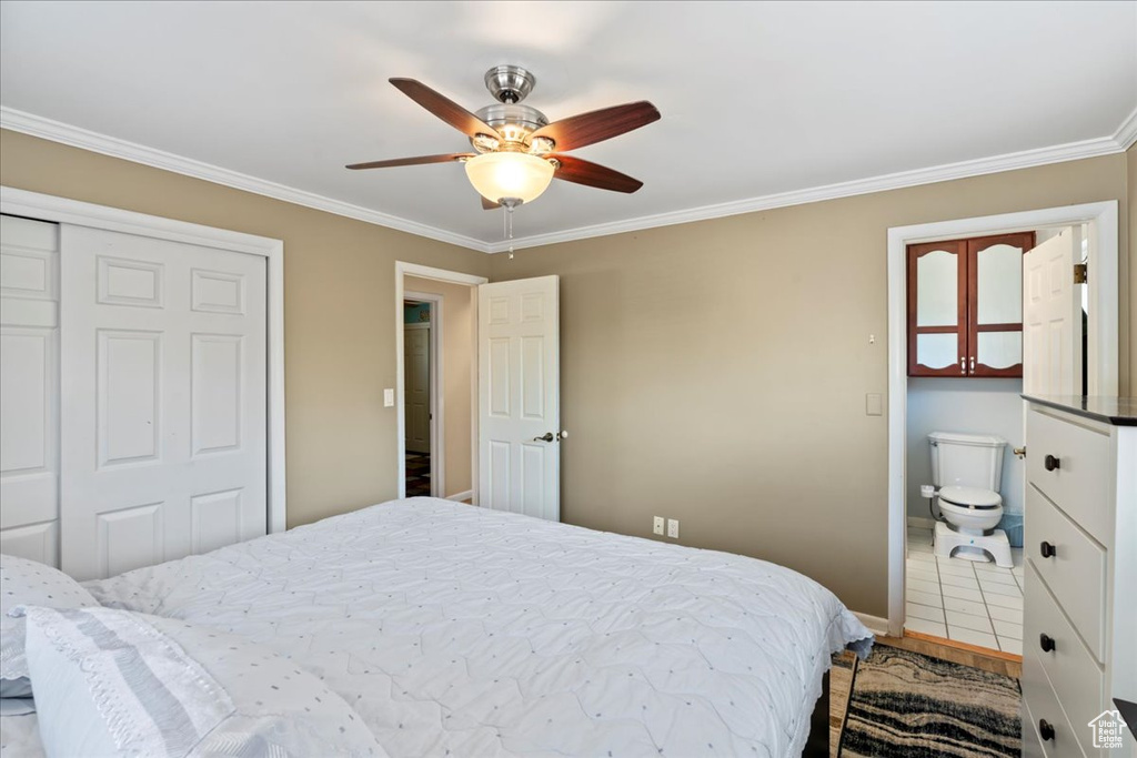 Bedroom with a closet, ensuite bathroom, crown molding, tile flooring, and ceiling fan