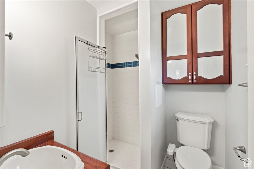 Bathroom featuring walk in shower, sink, and toilet