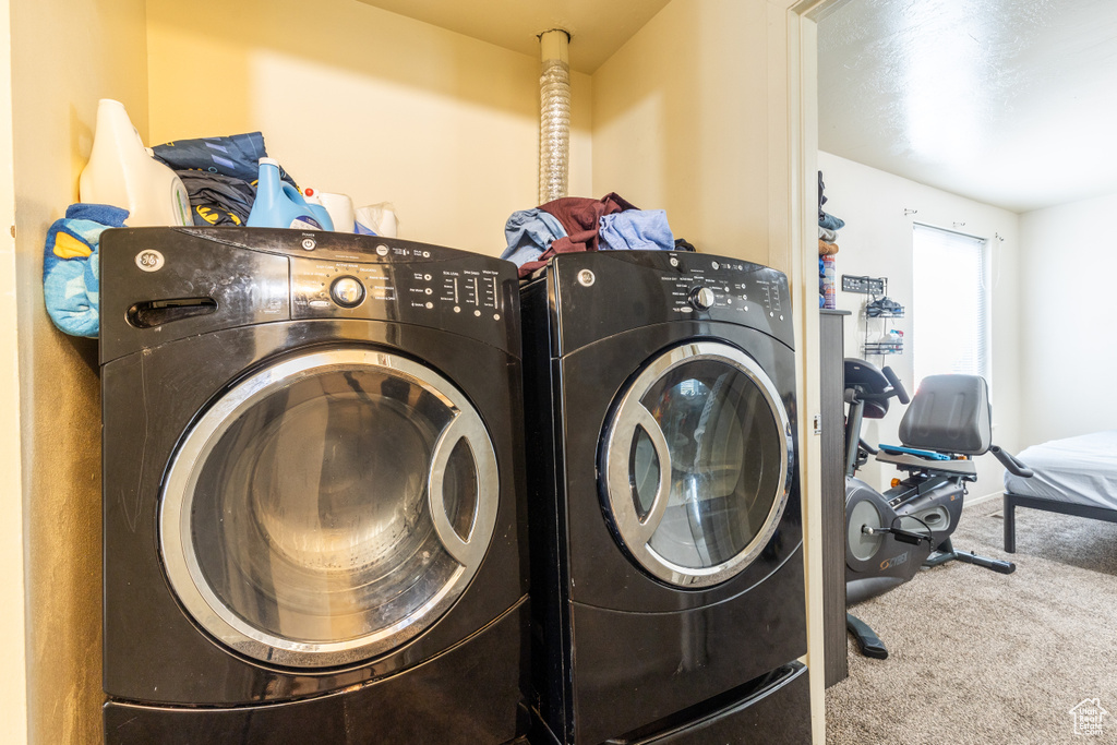 Clothes washing area featuring carpet flooring and separate washer and dryer