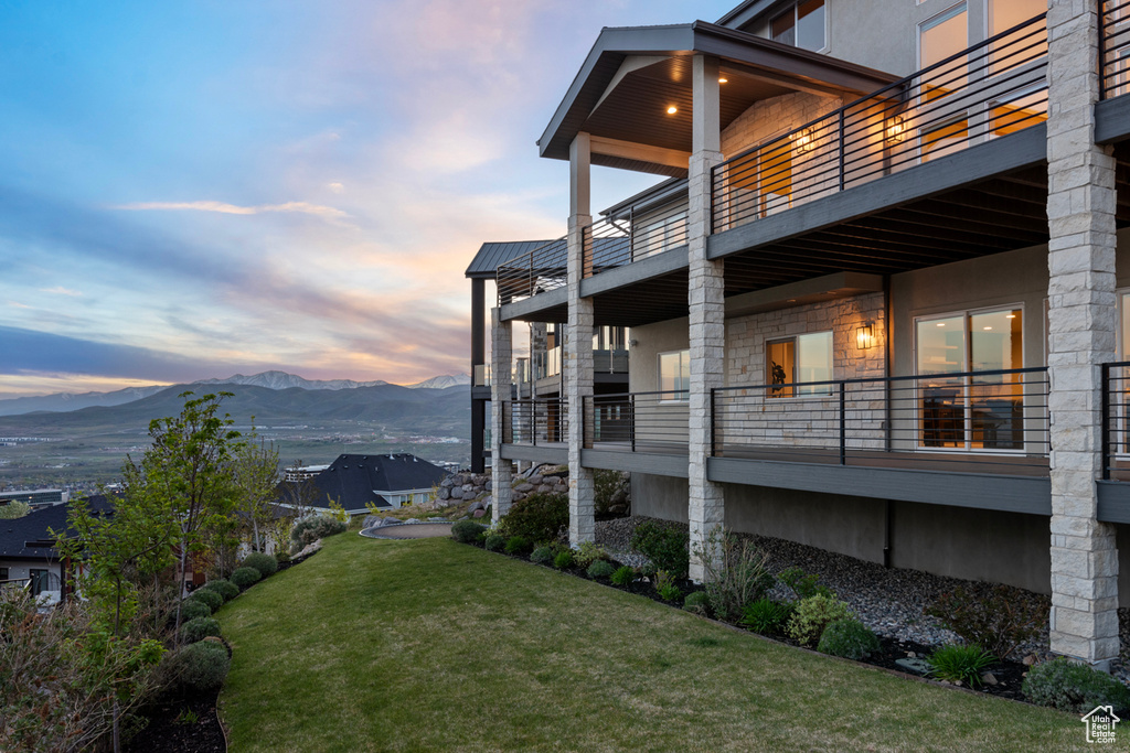 Yard at dusk with a mountain view and a balcony