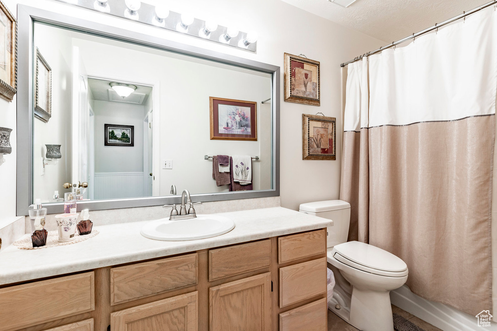 Bathroom with vanity, toilet, and a textured ceiling