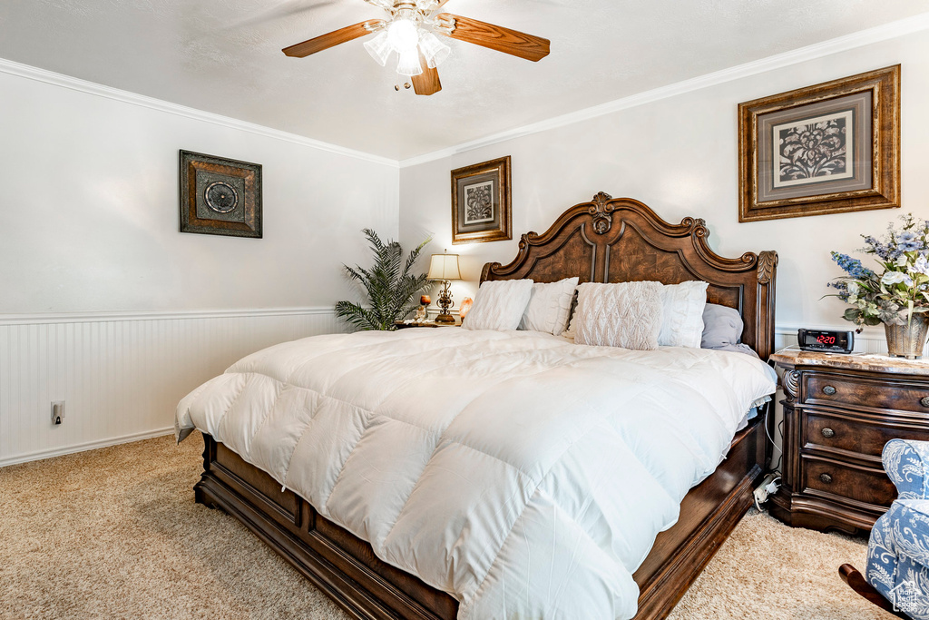 Bedroom featuring ornamental molding, carpet, and ceiling fan