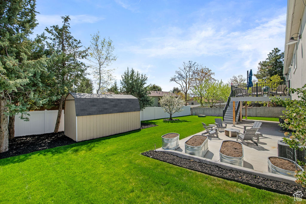 View of yard with a patio, an outdoor fire pit, and a storage shed